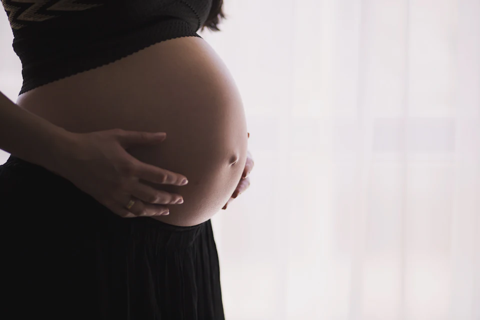 Pregnant woman cradling her belly