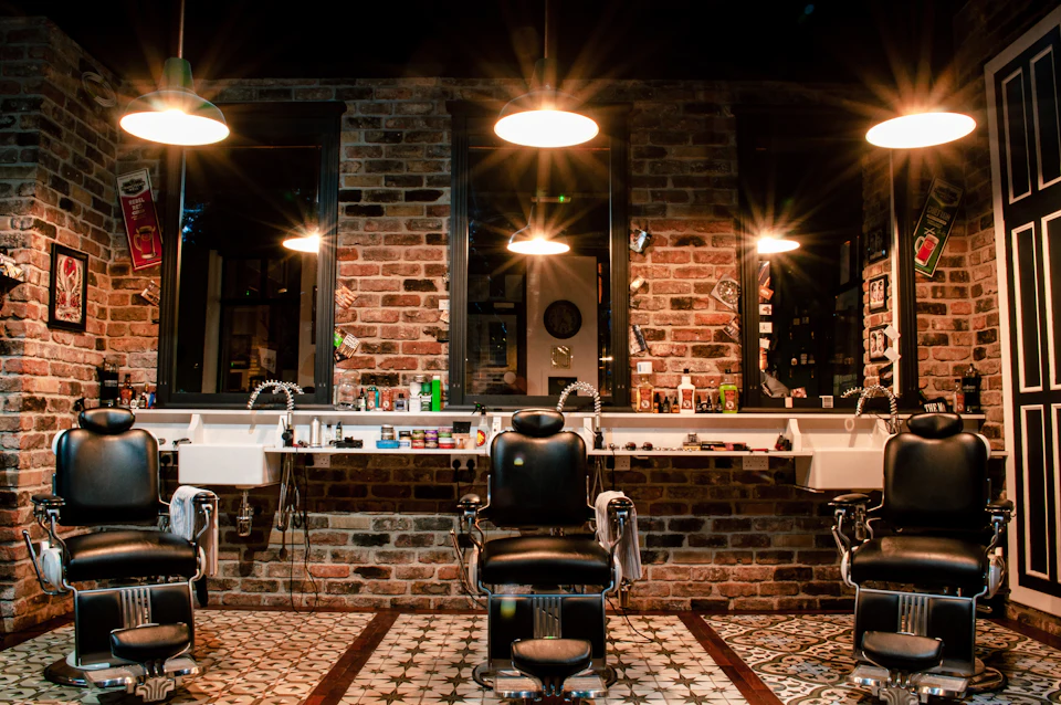 Black leather barber chair near brown brick wall