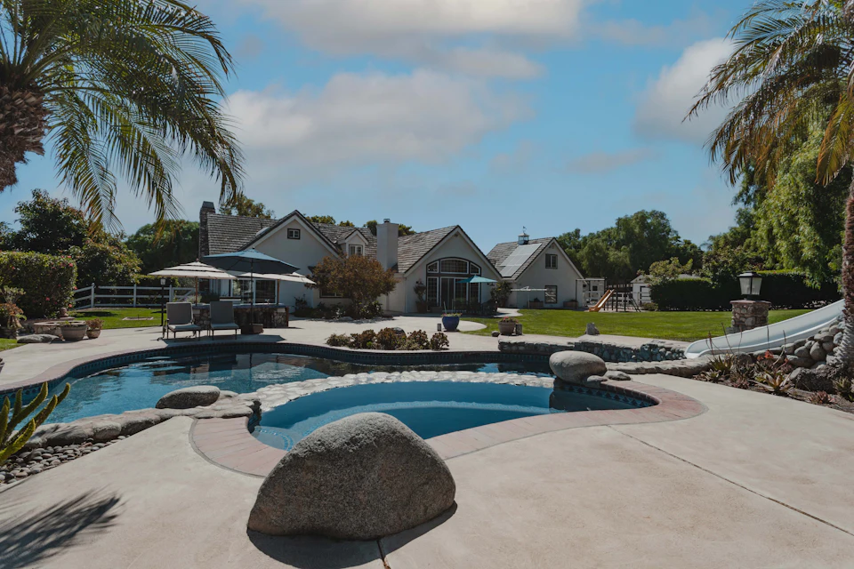 A pool surrounded by palm trees and landscaping