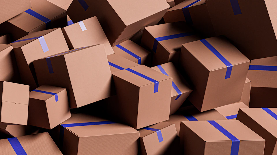 A large pile of brown cardboard boxes with blue tape