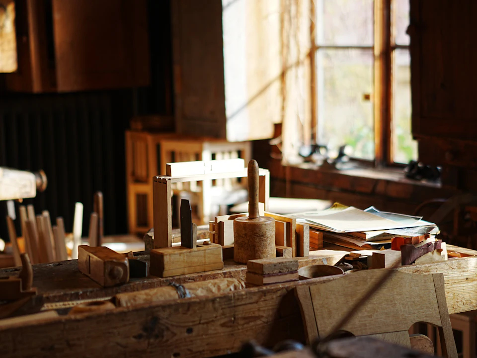 Wooden woodworking tools on a workbench in a sunlit workshop